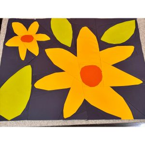 flower quilt block made with yellow, orange, green, and navy fabric