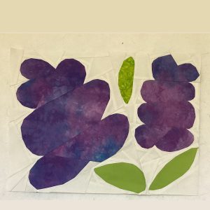 lilac quilt block made with batik purple and green fabric on a white background