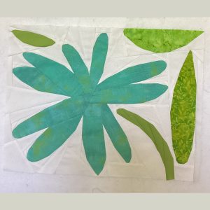 abstract flower quilt block made with aqua, green, and white fabric