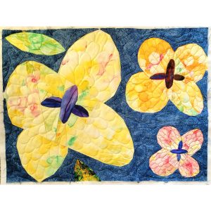 Wildflower-inspired quilt block made with yellow, orange, green, and navy batik fabrics