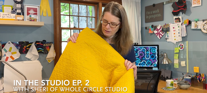 woman holding a yellow quilt